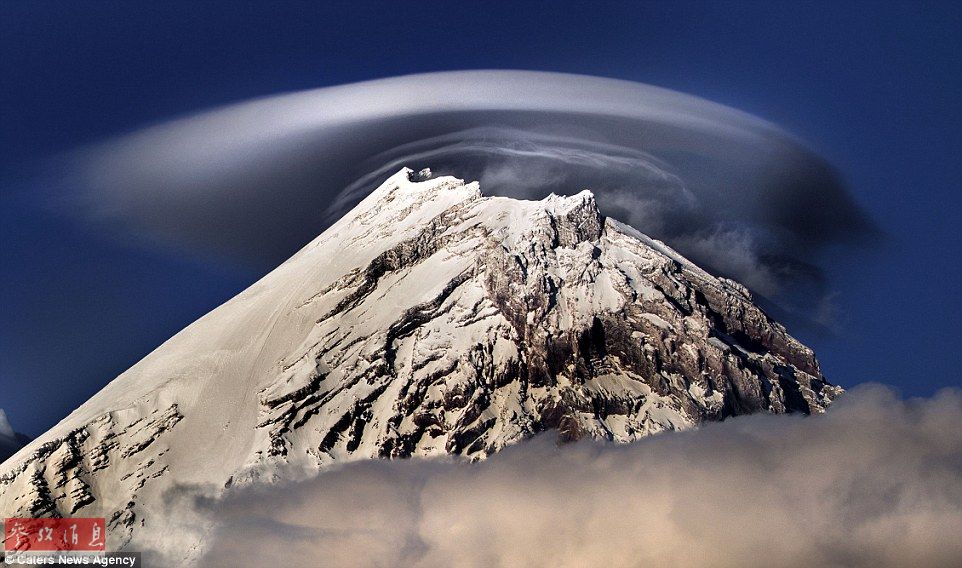 火山上籠罩著類似于外星飛碟形狀的云彩，場景猶如科幻大片。
