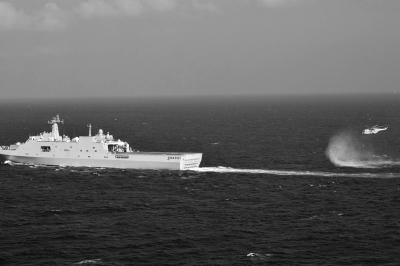 11日，抵達馬航飛機失聯(lián)海區(qū)的海軍井岡山艦與艦載直升機協(xié)同展開立體搜救行動。新華社發(fā)