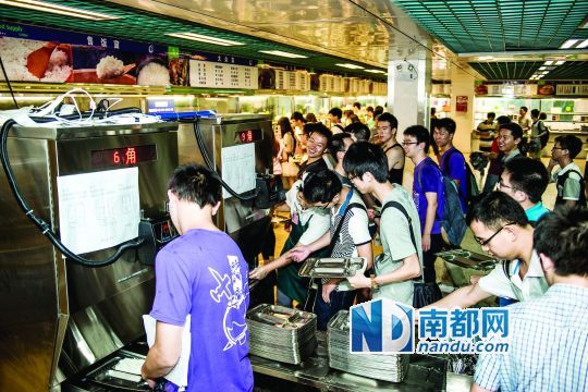 昨日，華南理工大學一食堂內(nèi)，學生們正在使用新安裝的自動打飯機打飯。中新社發(fā)
