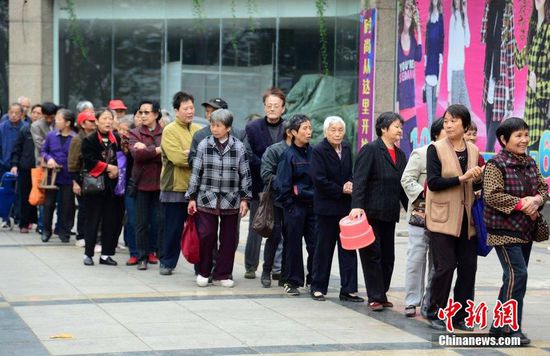 圖為10月28日，在江西九江市一家羊絨皮草服裝服飾博覽會(huì)現(xiàn)場(chǎng)，老人們正在頂著寒風(fēng)排隊(duì)等待領(lǐng)取10元代金劵。