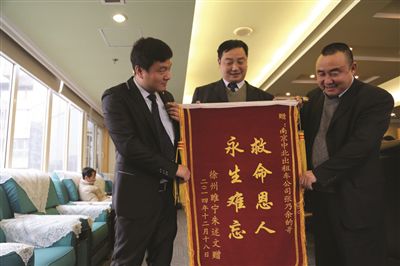 張乃余(中)和兩位救人的同伴一塊領(lǐng)獎。