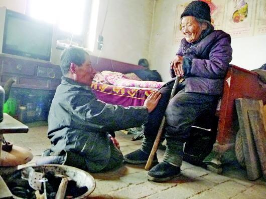 52歲的劉蘭山每天靠爬行照顧90歲的老母親。孫國祥 攝
