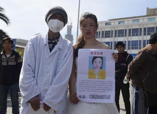昆明火車站廣場上，24歲的黃習菊身穿潔白的婚紗，帶著身患白血病的弟弟征婚。