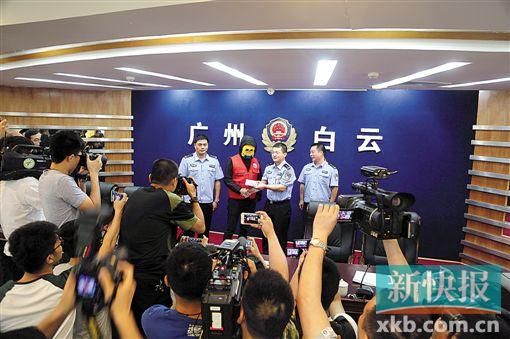 因舉報涉毒案件線索而獲獎的“快遞小哥”戴著面具領(lǐng)取獎金。
