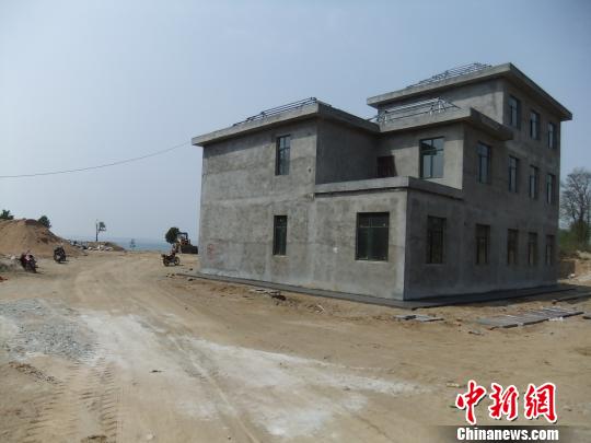 鴨河水庫庫區(qū)邊的新建別墅，一面墻上寫著“拆”，另一邊在加緊施工。吳揚　攝