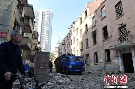 一位花甲老人站在即將拆除的樓房旁，默默地與“蘇聯(lián)樓”告別。　翟羽佳　攝