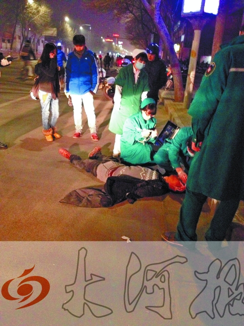 醉漢躺在地上，醫(yī)護(hù)人員對(duì)其進(jìn)行檢查。